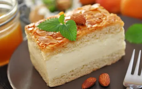 Gâteau nid d'abeille, une part crémeuse garnie d'amandes effilées et d'une touche de menthe. Parfait pour une recette gourmande.