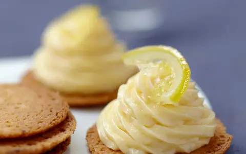 Deux petits gâteaux sur des biscuits sablés, ornés d'une délicieuse crème pâtissière citron et d'une fine tranche de citron.