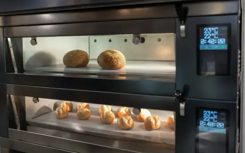 Deux étages de pains dorés dans un four professionnel. La fonction étuve four assure une cuisson parfaite.