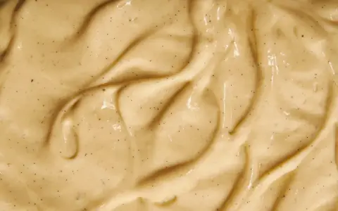 Texture onctueuse de crème pâtissière mousseuse, parsemée de points de vanille.