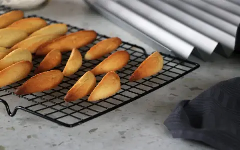 Biscuits dorés en forme de dent de loup refroidissent sur une grille.