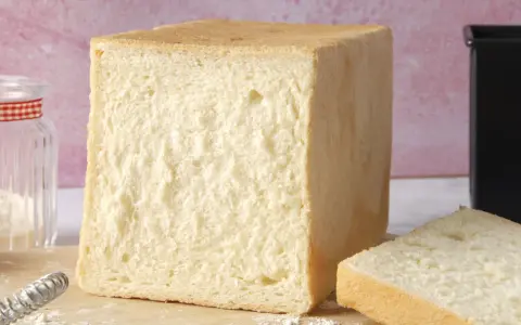 Un pain de mie parfait, tout juste sorti du four. La cuisson du pain de mie est une étape clé pour obtenir cette mie aérée et cette croûte dorée.