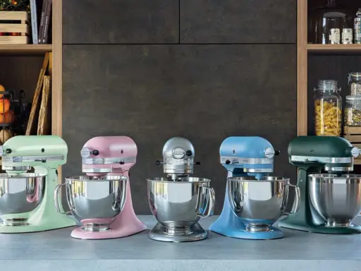 Cinq robots pâtissiers KitchenAid Classic ou Artisan de couleurs vives alignés sur un comptoir.
