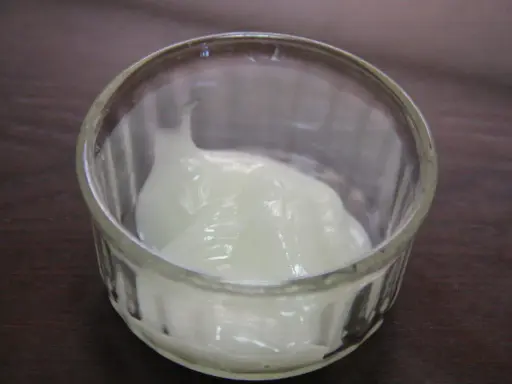Un pot en verre contient une substance blanche et crémeuse. On se demande : trimoline c'est quoi ? C'est peut-être un ingrédient de pâtisserie.