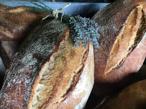 Baguettes dorées, garnies de lavande fraîche. Un délice artisanal, parfait avec du levain avec levure de boulanger.