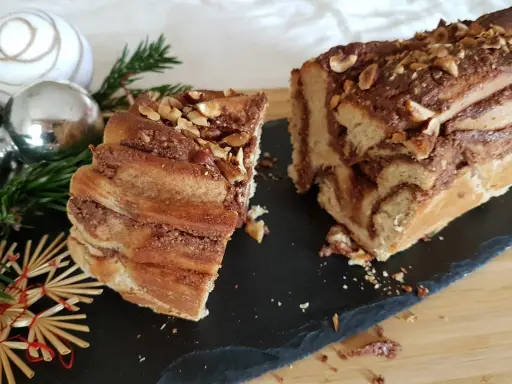 Délicieuse babka recette, un gâteau tressé au chocolat et noisettes, orné de décorations de Noël.