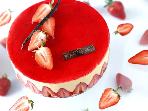 Gâteau fraisier à la crème mousseline, décoré de fraises fraîches et d'une gousse de vanille. Parfait pour une recette d'anniversaire.