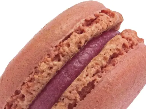Un délicieux macaron framboise, avec sa coque rose pâle et sa ganache violette intense.