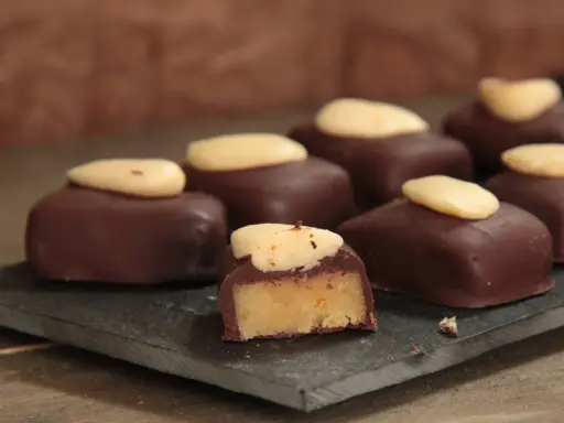 Délicieux bonbons au chocolat noir, garnis d'une pâte d'amande et surmontés d'une amande entière. Une recette gourmande à essayer !
