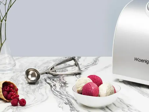 La turbine à glace Koenig HF340 prépare de délicieuses glaces maison. Une cuillère à glace et des fruits rouges complètent la scène.