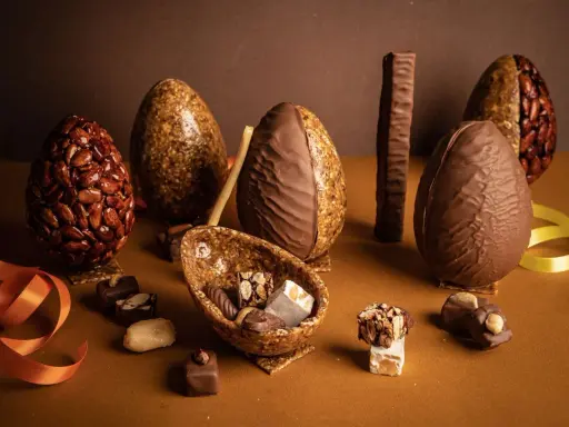Œufs en chocolat et nougatine, certains décorés d'amandes croquantes. Une composition gourmande pour Pâques.