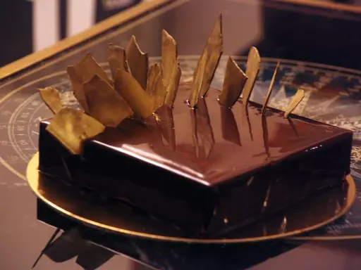 Gâteau royal chocolat Michalak, un délice glacé aux éclats dorés, prêt à être dégusté.