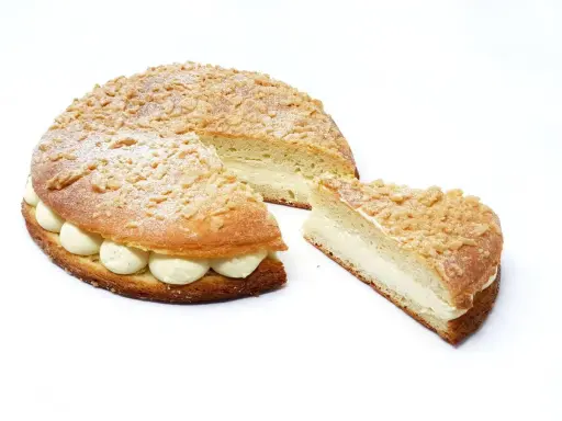 La tropézienne, le meilleur pâtissier, est une brioche garnie de crème onctueuse, saupoudrée de sucre glace et de crumble croustillant.