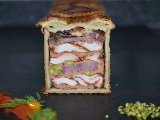 Pâté en croûte aux multiples couches de viandes, pistaches et gelée. Une œuvre d'art culinaire digne de la recette du meilleur pâté en croûte du monde.