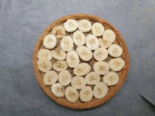 Tarte banoffee origine : rondelle de bananes sur une pâte sablée, prête à être dégustée.