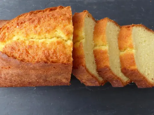 Un quatre-quarts breton, doré et moelleux, coupé en tranches sur fond sombre. Parfait pour une recette simple et gourmande.