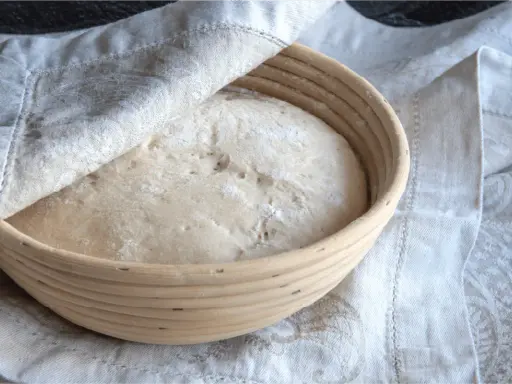 Pâte à pain dans un banneton, prête à lever. Trop de levure dans le pain peut entraîner des conséquences indésirables sur la texture et le goût.
