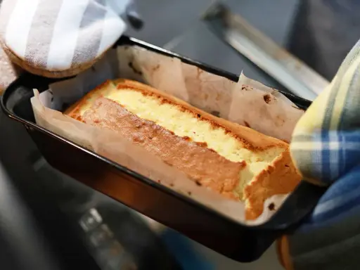 Un gâteau doré sort du four, sa pâte à gâteau parfaitement cuite dans son moule.