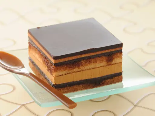 Un délicieux gâteau Opéra, une recette facile à réaliser, avec ses couches de biscuit, de crème au café et de ganache au chocolat.