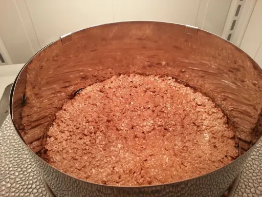 Fond de gâteau croustillant sans cuisson, une texture gourmande de chocolat et de riz soufflé dans un cercle à pâtisserie.