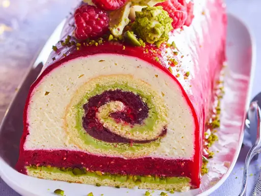 Bûche de Noël aux pistaches et framboises, un délice visuel et gustatif. La recette buche pistache framboise parfaite pour les fêtes.