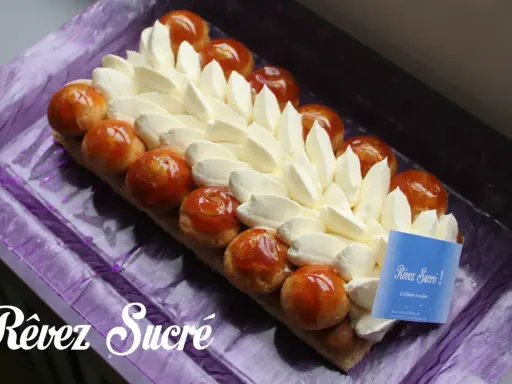 Un déliceux saint honoré rectangulaire, orné de crème onctueuse et de profiteroles caramélisées, prêt à être dégusté.