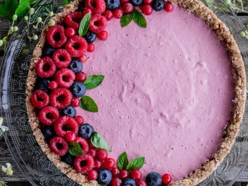 Délicieuse tarte aux fruits avec une garniture rose et des framboises, myrtilles et groseilles. La décoration tarte aux fruits est simple et élégante.