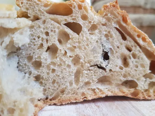 Gros trous dans le pain : astuces pour les éviter. La mie aérée et irrégulière d'une tranche de pain au levain.