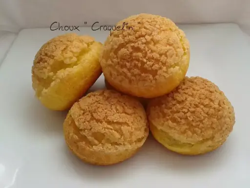 Quatre choux craquelin dorés et croustillants, prêts à être garnir.