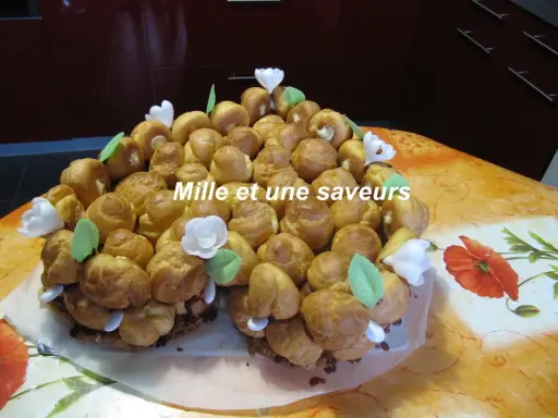 Magnifique chou pièce montée, un délice pour les yeux et les papilles, ornée de fleurs blanches et de feuilles vertes.