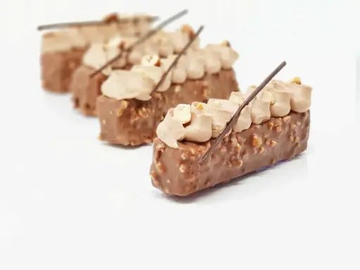 Délicieux entremets chocolat praliné, recouverts de noisettes croquantes et surmontés d'une crème onctueuse.