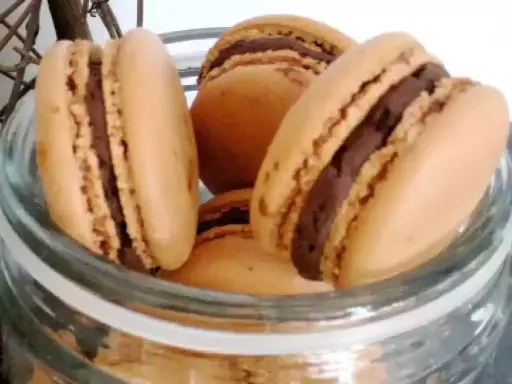 Délicieux macarons à la ganache chocolat, prêts à être dégustés dans un bocal en verre.