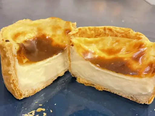 Flan pâtissier coupé en deux, montrant sa texture crémeuse. La cuisson en chaleur tournante ou pas, a donné une belle coloration dorée.