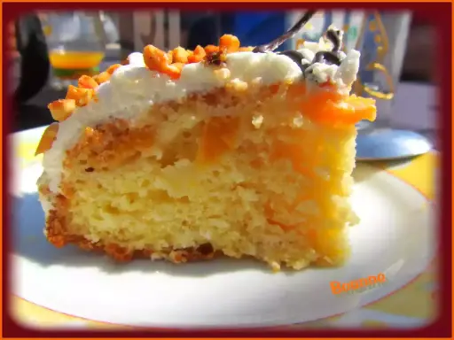 Tranche de gâteau moelleux avec des morceaux de pêche au sirop, nappage blanc et éclats d'amandes. Un délice fruité.