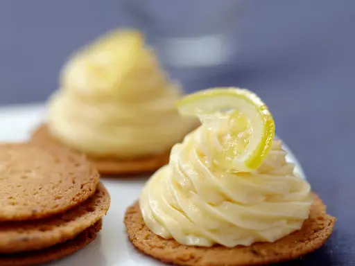 Deux petits gâteaux sur des biscuits sablés, ornés d'une délicieuse crème pâtissière citron et d'une fine tranche de citron.
