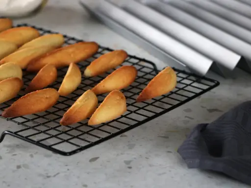 Biscuits dorés en forme de dent de loup refroidissent sur une grille.