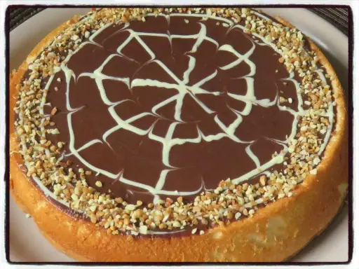 Gâteau génoise chocolat, ganache onctueuse, décor de chocolat blanc et éclats de noisettes. Un délice !