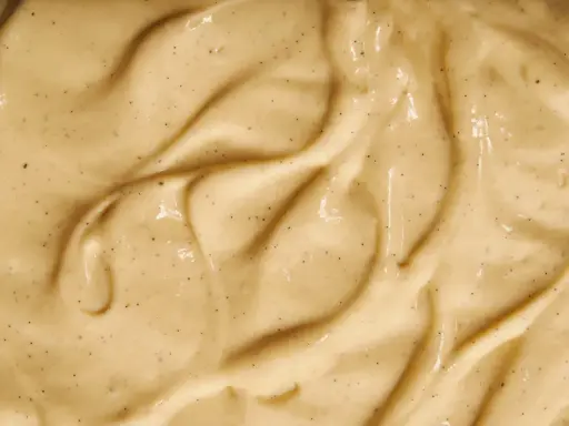 Texture onctueuse de crème pâtissière, parsemée de points de vanille, prête à être utilisée avec de la gélatine pour des desserts parfaits.