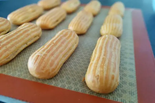 Des éclairs dorés prêts pour garnir, issus d'une recette pâte à choux éclair réussie.