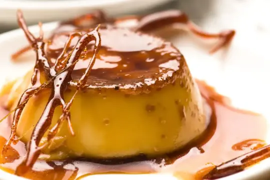 Un délice doré : la vraie crème caramel, nappée d'un caramel liquide et ornée de fils de sucre croustillants. Un dessert qui fait fondre de plaisir.