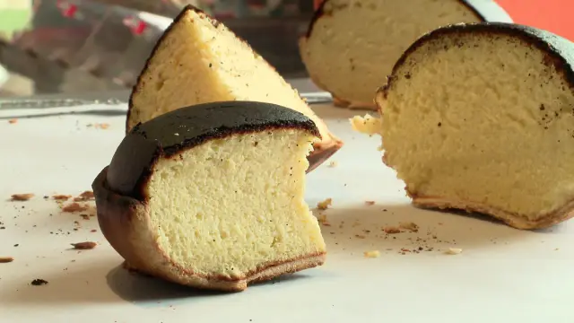 Tranches de tourteau fromager, un gâteau au fromage à la croûte foncée et à la mie aérée, parsemé de poivre.