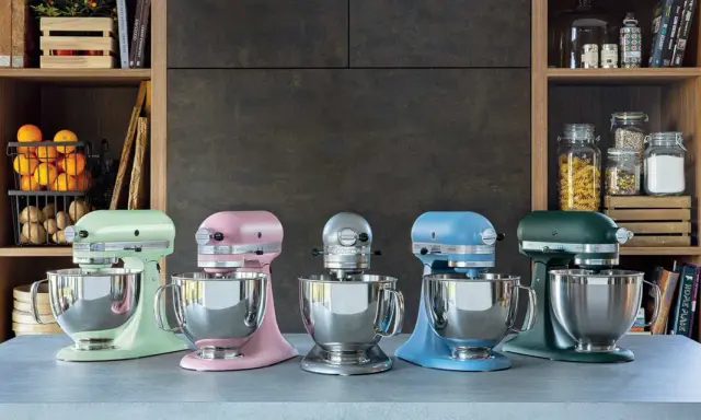 Cinq robots pâtissiers KitchenAid Classic ou Artisan de couleurs vives alignés sur un comptoir.