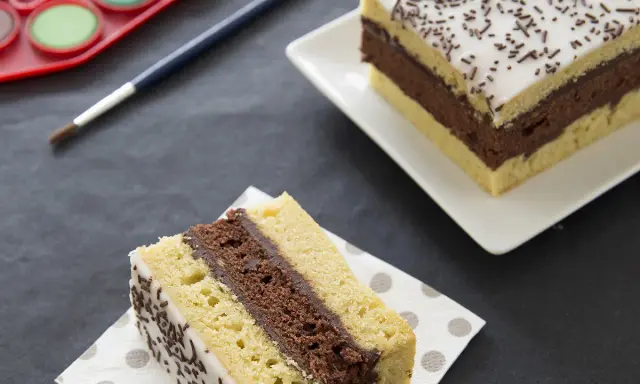 Une tranche de gâteau napolitain, digne du meilleur pâtissier, avec une palette de peinture et un pinceau.