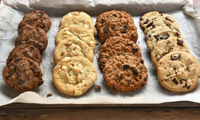 Une variété de biscuits moelleux, aux pépites de chocolat, blancs et aux flocons d'avoine, prêts à être dégustés. Parfait pour une recette facile.