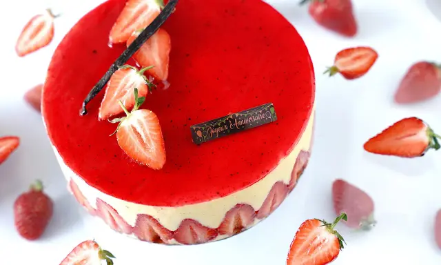 Gâteau fraisier à la crème mousseline, décoré de fraises fraîches et d'une gousse de vanille. Parfait pour une recette d'anniversaire.