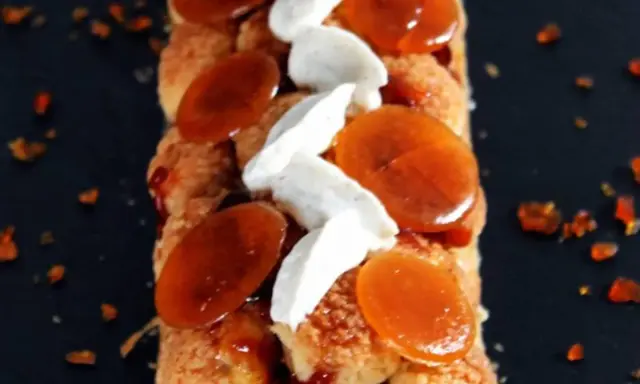 Bûche Saint Honoré gourmande, garnie de choux craquelins, crème onctueuse et éclats de caramel ambré. Un délice visuel et gustatif.