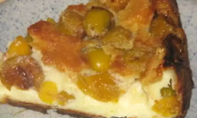 Une part de flan aux mirabelles, avec sa croûte dorée et sa garniture crémeuse aux fruits jaunes.