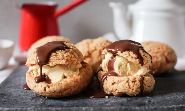 Délicieux profiteroles chocolat, garnis de glace et nappés de sauce au chocolat, prêts à être dégustés.