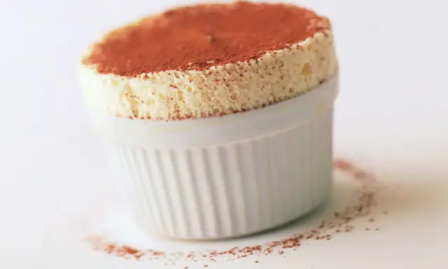 Un aérien soufflé au grand marnier, saupoudré de cacao, dans un ramequin blanc. Un délice léger et parfumé.