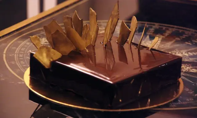 Gâteau royal chocolat Michalak, un délice glacé aux éclats dorés, prêt à être dégusté.